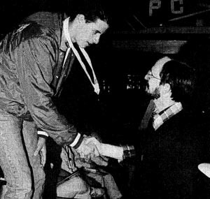 Matt Shenker receives one of his three gold medals from Swimming World Magazine editor Bob lngram.
