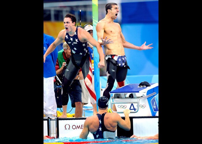 BEIJING, CHINA AUGUST 11TH, 2008--USA' Garrett Weber-Gale, left, and Michael Phelps celebrate with Jason Lezak, in the pool, the gold medal in the 4x100 Freestyle Relay at the 2008 Beijing Olympics.