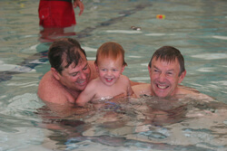 Johnny Johnson, left, teaches Mark Schubert's grandson Luke how to swim at the Blue Buoy Swim School