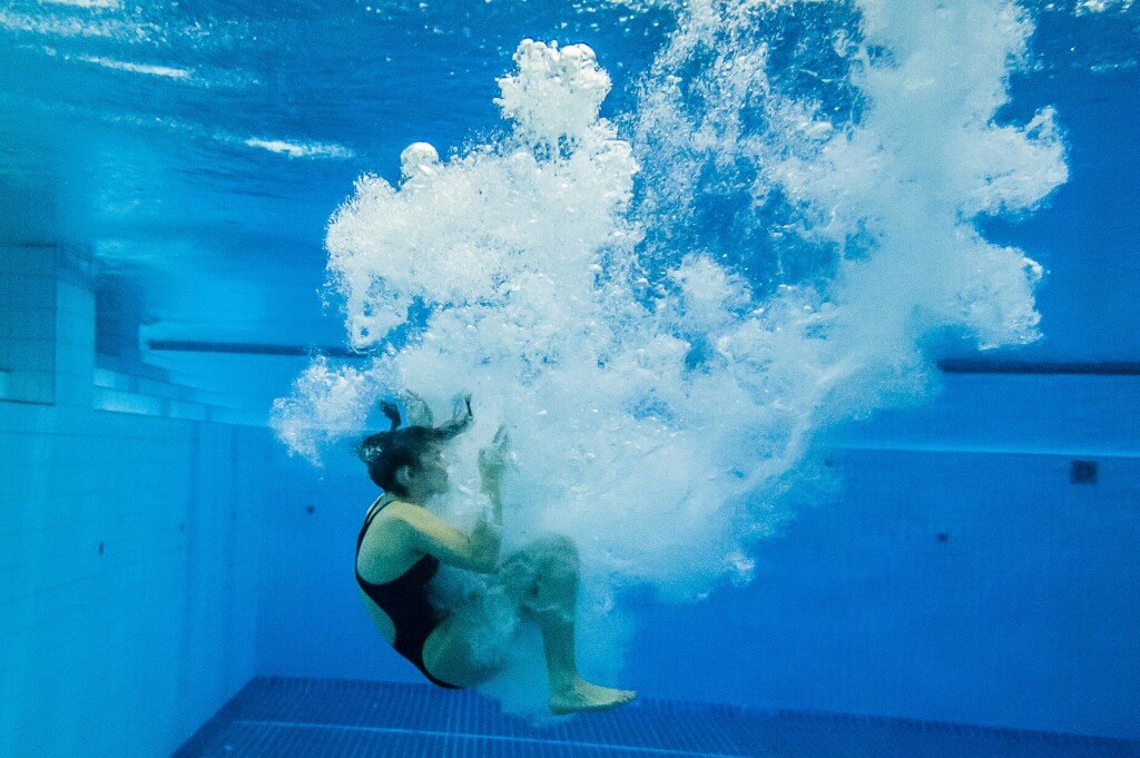 A diver entering the water from the 3 meter springboard.