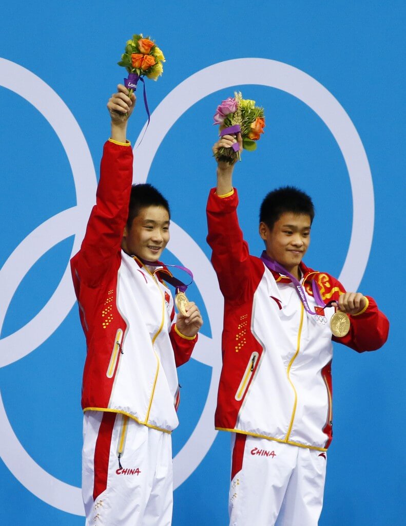 Jul 30, 2012; London, United Kingdom; Cao Yuan and Zhang Yanquan (CHN) celebrate with their gold medals after winning the men's 10m platform synchronized diving final during the London 2012 Olympic Games at Aquatics Centre. Mandatory Credit: Rob Schumacher-USA TODAY Sports
