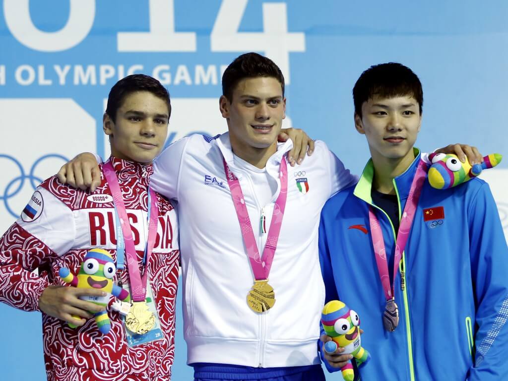 (140818) -- NANJING, Aug. 18, 2014 (Xinhua) -- Gold medalist Evgeny Rylov of Russia and Simone Sabbioni of Italy,bronze medalist Li Guangyuan of China pose for a photo on the podium during the awarding ceremony of men?s 100m backstroke final at Nanjing 2014 Youth Olympic Games in Nanjing, east China's Jiangsu Province, Aug. 18, 2014. (Xinhua/Fei Maohua) (yqq)