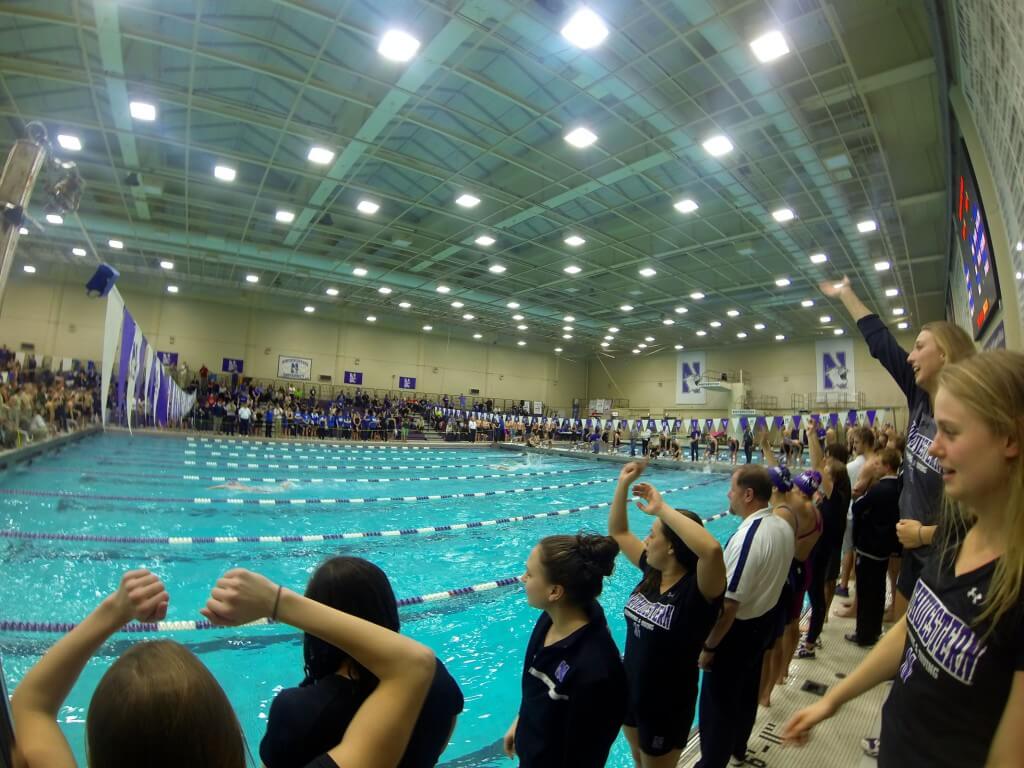 Northwestern team members anxiously watch their A- 400 free relay as they attack the pool record.