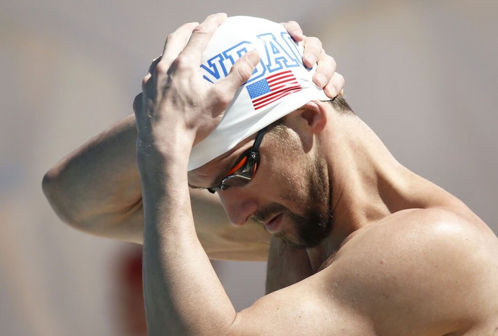 Apr 16, 2015; Mesa, AZ, USA; Michael Phelps adjusts his cap before swimming in the Men's 100 meter butterfly prelims during the 2015 Arena Pro Swim Series at the Skyline Aquatic Center. Mandatory Credit: Rob Schumacher/Arizona Republic via USA TODAY Sports