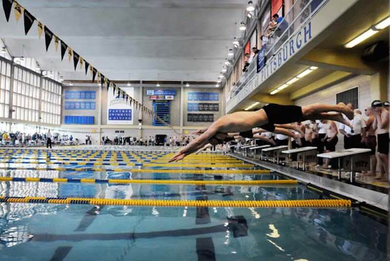Times photo by SALLY MAXSON WPIAL swimming championships at the University of Pittsburgh Thursday. Lead swimmers dive into the water at the start of the boys 200 freestyle relay.