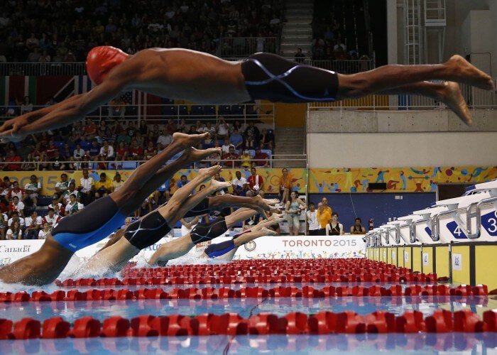 Jul 17, 2015; Toronto, Ontario, CAN; Frantz Dorsainvil of Haiti (top) is late off the starting blocks as the rest of the field dives into the pool at the start of the men's swimming 50m freestyle preliminary heats during the 2015 Pan Am Games at Pan Am Aquatics UTS Centre and Field House. Mandatory Credit: Rob Schumacher-USA TODAY Sports