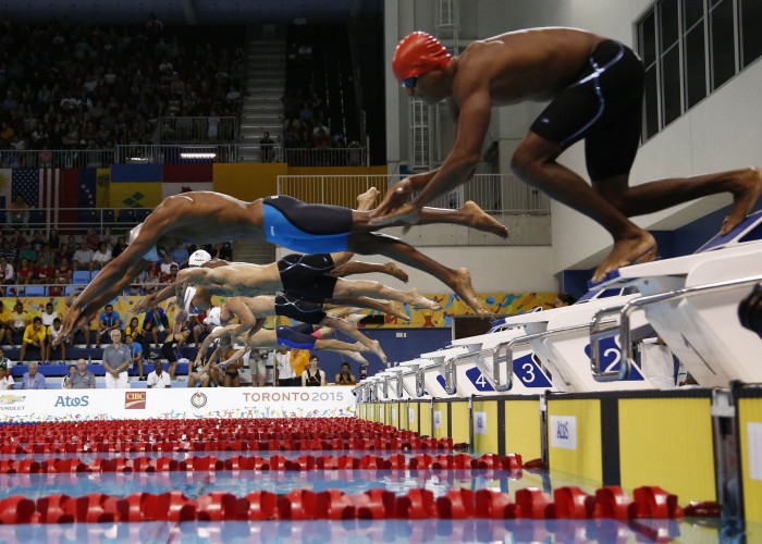 Jul 17, 2015; Toronto, Ontario, CAN; Frantz Dorsainvil of Haiti (right) is late off the starting blocks as the rest of the field dives in at the start of the men's swimming 50m freestyle preliminary heats during the 2015 Pan Am Games at Pan Am Aquatics UTS Centre and Field House. Mandatory Credit: Rob Schumacher-USA TODAY Sports