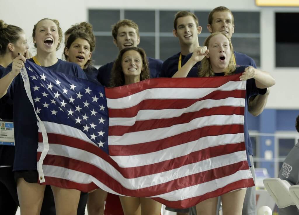 Jul 17, 2015; Toronto, Ontario, CAN; United States swim team members wave a flag during the medal ceremony for the women's swimming 400m individual medley final the 2015 Pan Am Games at Pan Am Aquatics UTS Centre and Field House. Mandatory Credit: Erich Schlegel-USA TODAY Sports