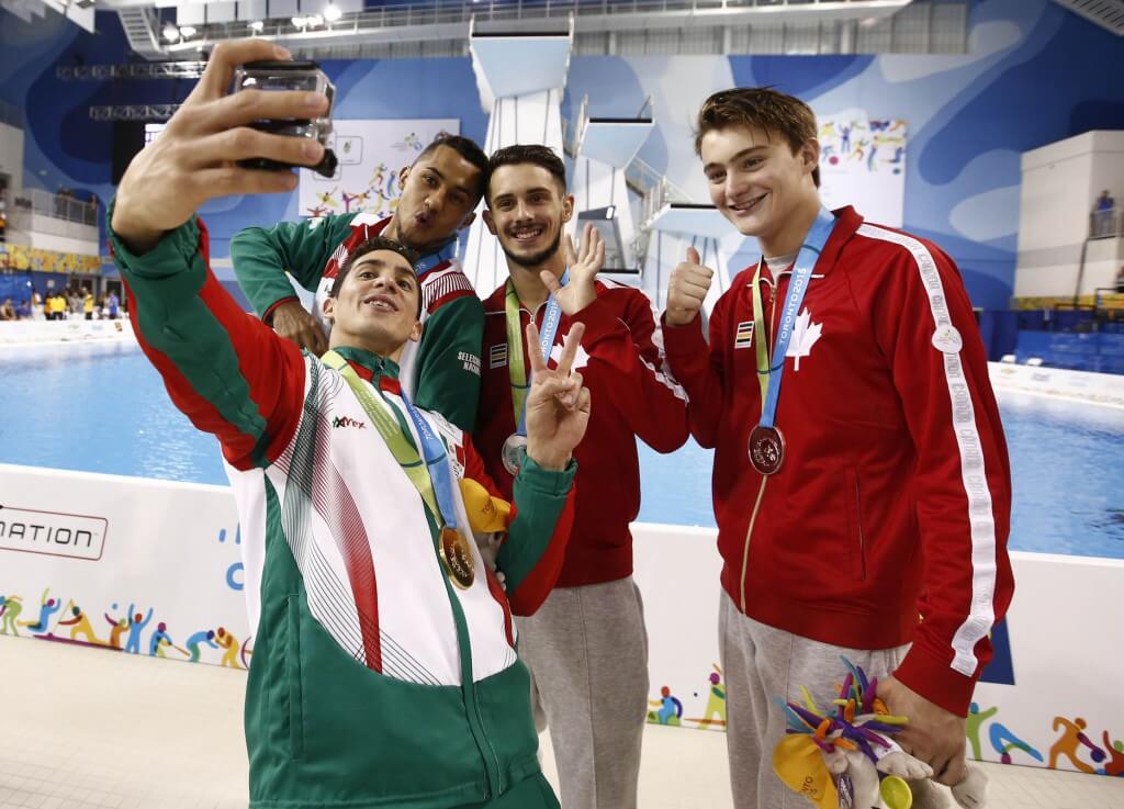 Jul 13, 2015; Toronto, Ontario, USA; Jahir Ocampo and Rommel Pacheco of Mexico (left) pose for a photo with Philippe Gagne and Francois Imbeau-Dulac of Canada after the men's synchronised diving 3m springboard final the 2015 Pan Am Games at Pan Am Aquatics UTS Centre and Field House. Mandatory Credit: Rob Schumacher-USA TODAY Sports