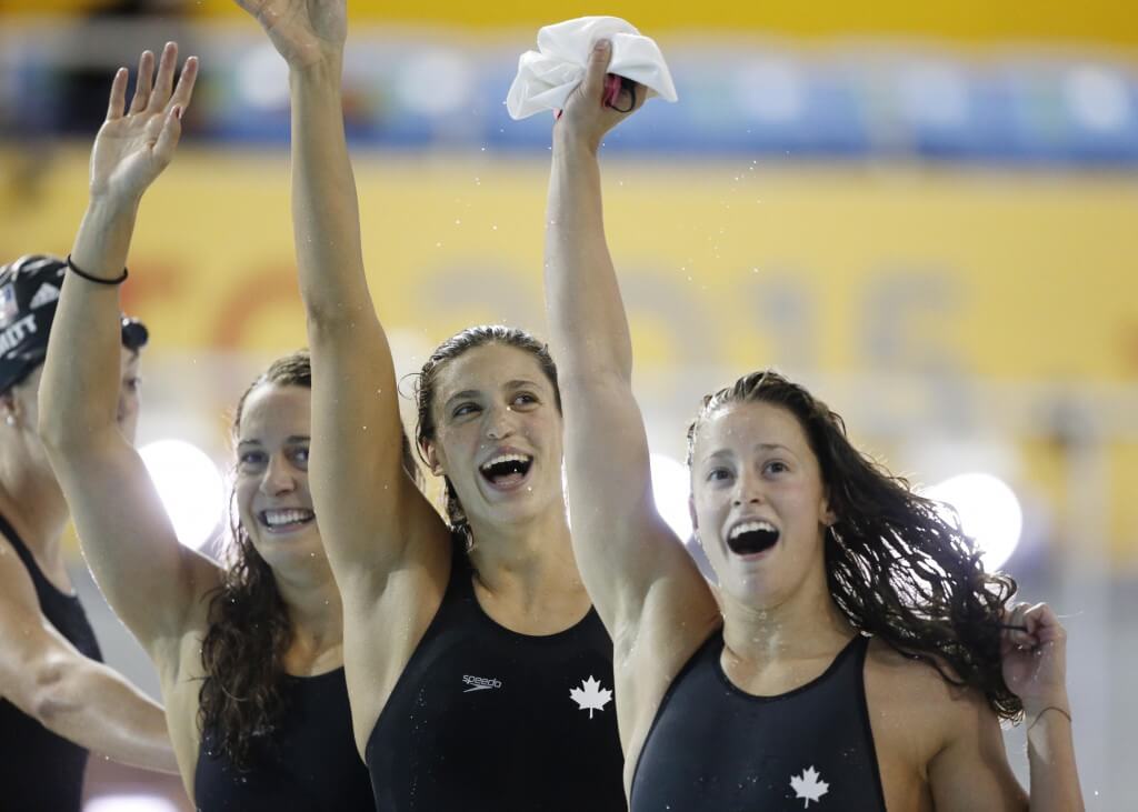 Jul 14, 2015; Toronto, Ontario, CAN; Sandrine Mainville , Katerine Savard and Michelle Williams of Canada celebrate after winning the women's 4x100m freestyle relay final during the 2015 Pan Am Games at Pan Am Aquatics UTS Centre and Field House. Mandatory Credit: Erich Schlegel-USA TODAY Sports
