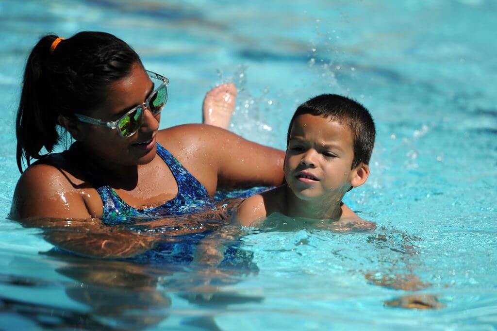 Swim instructor Jessica Raya assists Derek Muniz, 4, as he works on using his hands and feet at the same time during a class Monday at Thomas Pool. The swim classes, available to all ages and all swim levels, run every two weeks. (Photo by Daniel Cernero, Fort Hood Sentinel Sports Editor)