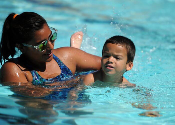 Swim instructor Jessica Raya assists Derek Muniz, 4, as he works on using his hands and feet at the same time during a class Monday at Thomas Pool. The swim classes, available to all ages and all swim levels, run every two weeks. (Photo by Daniel Cernero, Fort Hood Sentinel Sports Editor)
