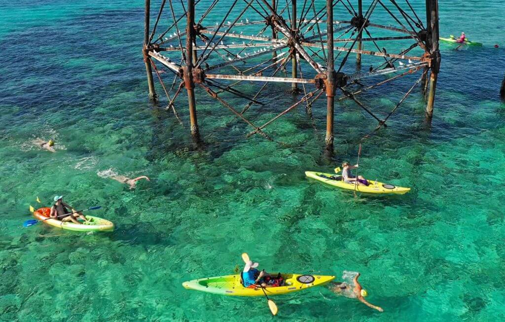 Kayakers escort swimmers around Alligator Reef Lighthouse during the 