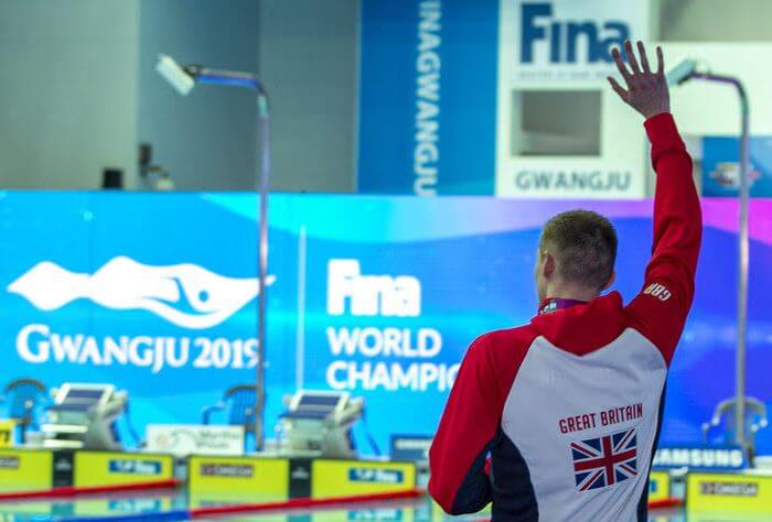 Third placed Duncan Scott of Great Britain is being celebrated by other swimmers, coaches and most of the crowd on his way out after refusing to pose with winner Yang Sun of China (not pictured) during the medal ceremony for the men's 200m Freestyle Final during the Swimming events at the Gwangju 2019 FINA World Championships, Gwangju, South Korea, 23 July 2019.