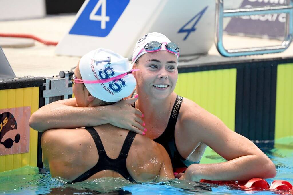 Golden smile from TSS Aquatic's Kiah Melverton and a hug for silver medal winning teammate Moesha Johnson.