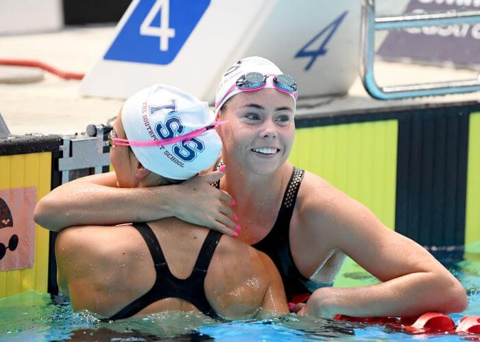 Golden smile from TSS Aquatic's Kiah Melverton and a hug for silver medal winning teammate Moesha Johnson.
