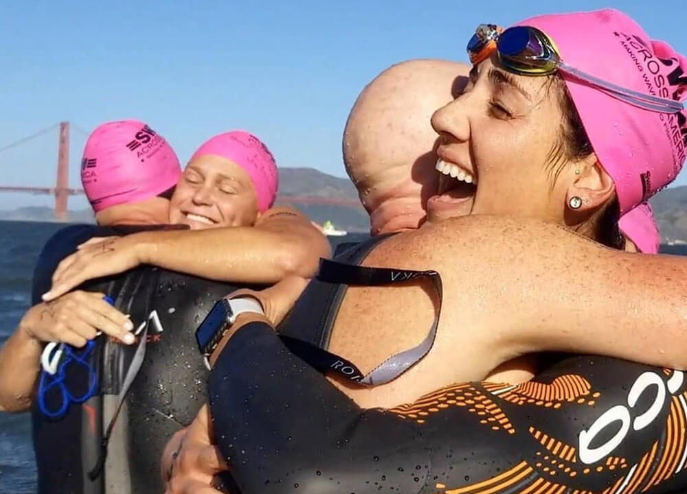 open-water-swimmers-in-pink-caps-hug-san-francisco