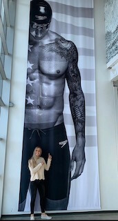 Meghan Haila and her giant sprinter of boyfriend on a Speedo mega poster - Photo Courtesy: Meghan Haila/Speedo megnahailacaelebdresselposter