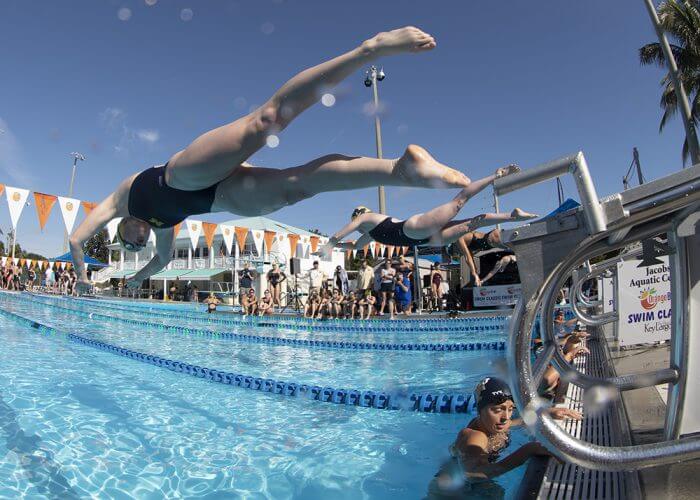 From left, University of Michigan swimmers Caroline Sisson and Miranda Tucker leap off the starting blocks during the Orange Bowl Swim Classic Friday, Jan. 3, 2020, in Key Largo, Fla. The Wolverines took top honors in the women’s division, while the University of Wisconsin - La Crosse won the men’s division. The event was a highlight of the winter collegiate swimming training season in the Florida Keys. FOR EDITORIAL USE ONLY (Stephen Frink/Florida Keys News Bureau/HO