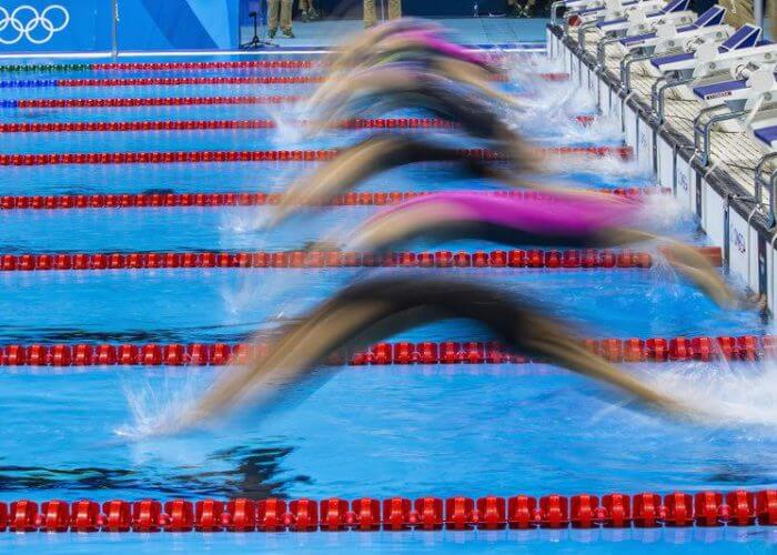 Swimmer start for the Backstroke leg in the women's 4x100m Medley Relay Heat 2