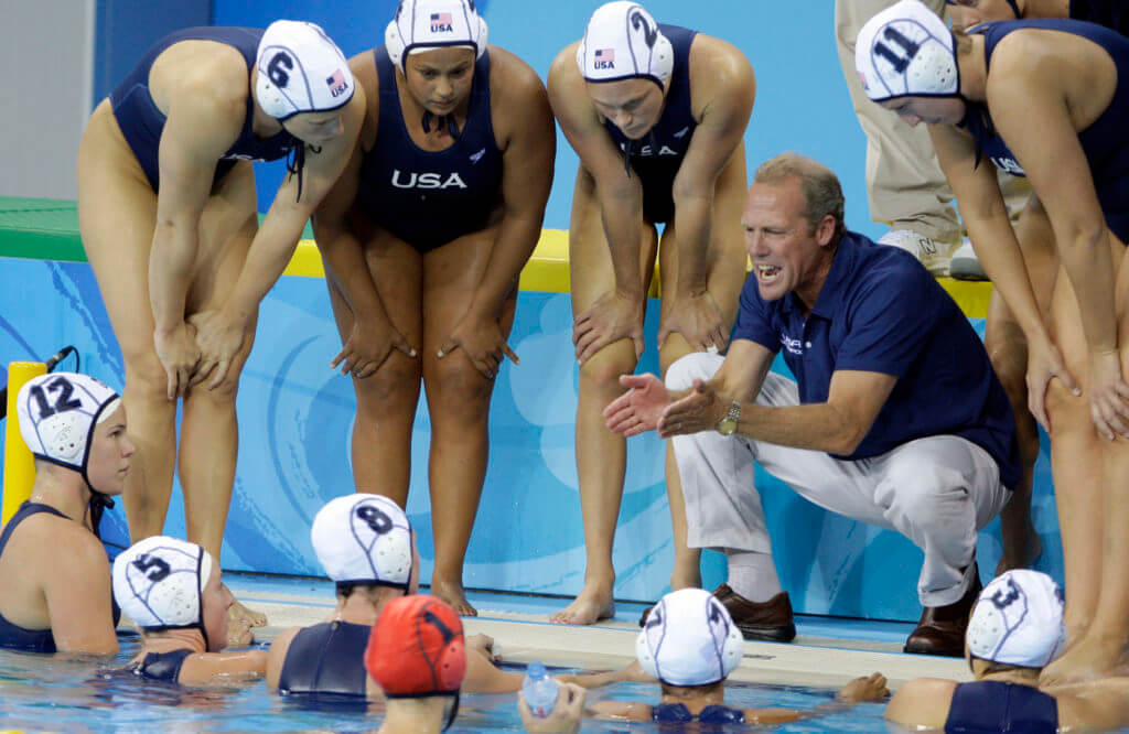 usa-water-polo-USA's head coach Guy Baker talks with his players during a time out in a preliminary round women's water polo match against Italy at the Beijing 2008 Olympics in Beijing, Wednesday, Aug. 13, 2008. The teams tied 9-9. (AP Photo/Mark Humphrey)