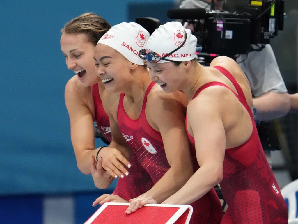 Jul 25, 2021; Tokyo, Japan; Kayla Sanchez, Margaret Macneil and Rebecca Smith (CAN) celebrate after placing second during the women's 4x100m freestyle relay final during the Tokyo 2020 Olympic Summer Games at Tokyo Aquatics Centre. Mandatory Credit: Robert Hanashiro-USA TODAY Network