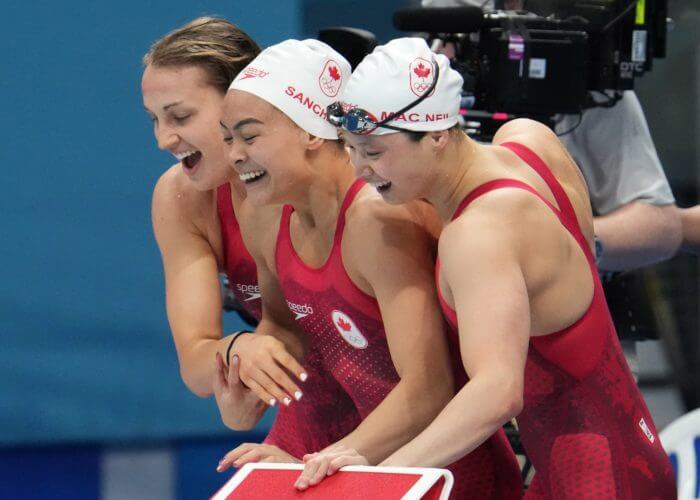 Jul 25, 2021; Tokyo, Japan; Kayla Sanchez, Margaret Macneil and Rebecca Smith (CAN) celebrate after placing second during the women's 4x100m freestyle relay final during the Tokyo 2020 Olympic Summer Games at Tokyo Aquatics Centre. Mandatory Credit: Robert Hanashiro-USA TODAY Network