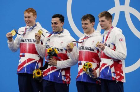 Jul 28, 2021; Tokyo, Japan; Great Britain relay team of Tom Dean (GBR) , James Guy (GBR) , Matthew Richards (GBR) and Duncah Scott (GBR) celebrate their gold medals during the medals ceremony for the men's 4x200m freestyle relay during the Tokyo 2020 Olympic Summer Games at Tokyo Aquatics Centre. Mandatory Credit: Rob Schumacher-USA TODAY Sports
