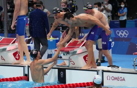 Jul 26, 2021; Tokyo, Japan; Zach Apple (USA) is congratulated by teammates after anchoring the USA to a gold medal in the men's 4x100m freestyle relay final during the Tokyo 2020 Olympic Summer Games at Tokyo Aquatics Centre. Mandatory Credit: Robert Hanashiro-USA TODAY Sports