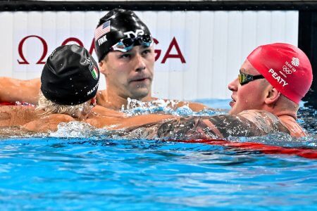 Nicolo Martinenghi of Italy, gold, Nic Fink of United States of America, silver, Adam Peaty of Great Britain, silver react after competing in the swimming 100m Breaststroke Men Final during the Paris 2024 Olympic Games at La Defense Arena in Paris (France), July 28, 2024.