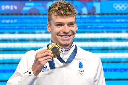 Leon Marchand of France shows the gold medal after competing in the swimming 400m Individual Medley Men Final with new Olympic Record during the Paris 2024 Olympic Games at La Defense Arena in Paris (France), July 28, 2024.