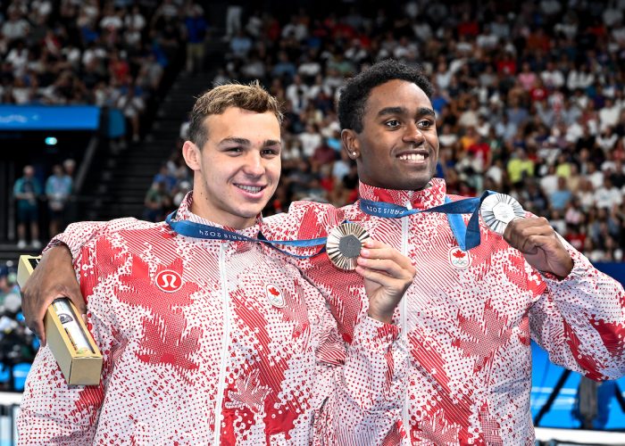 Ilya Kharun of Canada, bronze, and Josh Liendo of Canada, silver show the medals after competing in the swimming 100m Butterfly Men Final during the Paris 2024 Olympic Games at La Defense Arena in Paris (France), August 03, 2024.